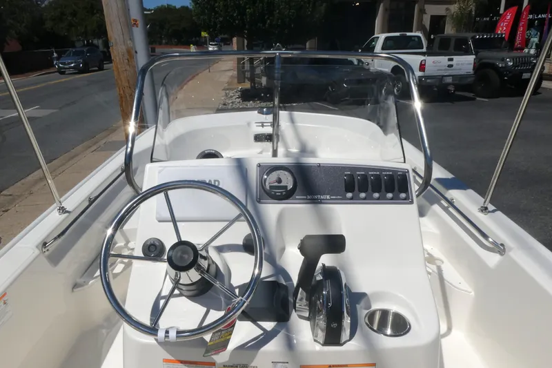 Slide: The Image of 2026 Boston Whaler 170 Montauk boat console with steering wheel and controls. - 7