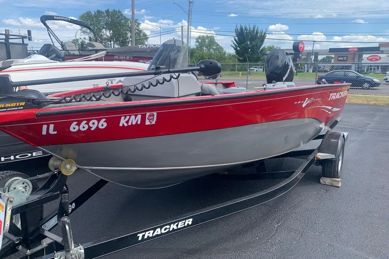 Slide: The Image of 2012 Tracker Pro Guide V-175 SC boat on trailer, red and silver, parked outdoors. - 4