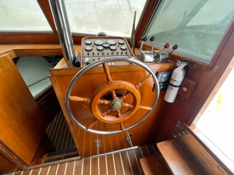 Slide: The Image of 1985 DeFever 40 Offshore Cruiser helm with wooden wheel and control panel. - 14