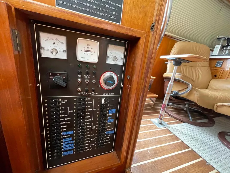 Slide: The Image of Electrical panel on 1985 DeFever 40 Offshore Cruiser, featuring gauges and switches in a wooden interior. - 15