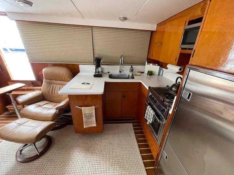 Slide: The Image of 1985 DeFever 40 Offshore Cruiser interior with kitchen and seating area. - 16