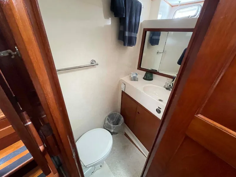 Slide: The Image of 1985 DeFever 40 Offshore Cruiser bathroom with wooden cabinetry and white fixtures. - 19