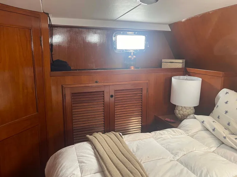 Slide: The Image of 1985 DeFever 40 Offshore Cruiser cabin with wooden interior and cozy bedding. - 23