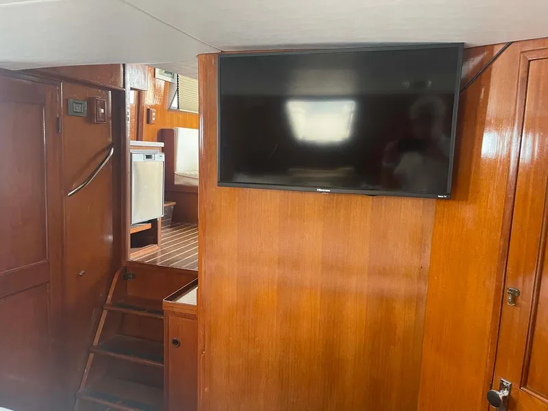 Slide: The Image of Interior of 1985 DeFever 40 Offshore Cruiser with wooden paneling and mounted TV. - 27