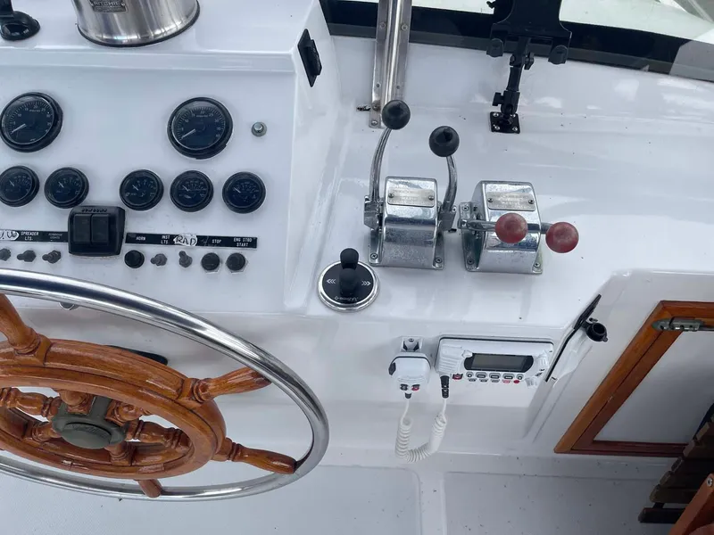 Slide: The Image of Control panel of 1985 DeFever 40 Offshore Cruiser with wooden steering wheel and throttle levers. - 40