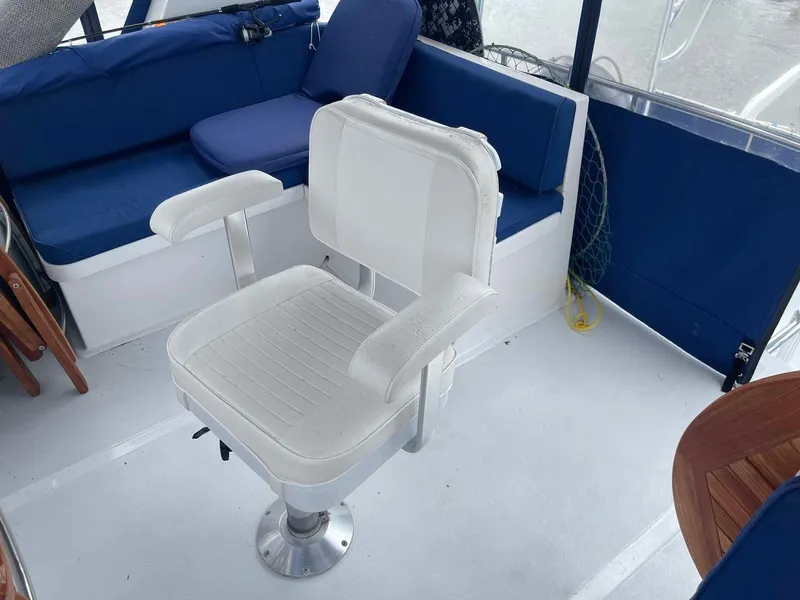 Slide: The Image of 1985 DeFever 40 Offshore Cruiser interior with white captain's chair and blue seating. - 42