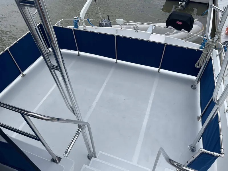 Slide: The Image of 1985 DeFever 40 Offshore Cruiser deck with blue railings and water view. - 43