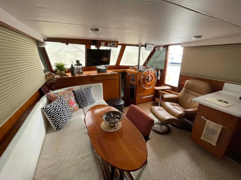 Slide: The Image of 1985 DeFever 40 Offshore Cruiser interior with cozy seating, wooden table, and helm station. - 9