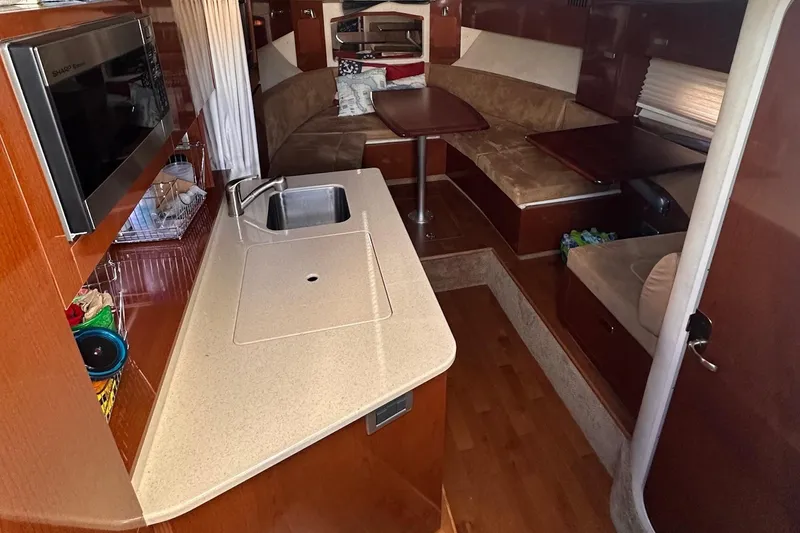 Slide: The Image of Interior of 2010 Sea Ray 310 Sundancer with kitchenette and seating area. - 11