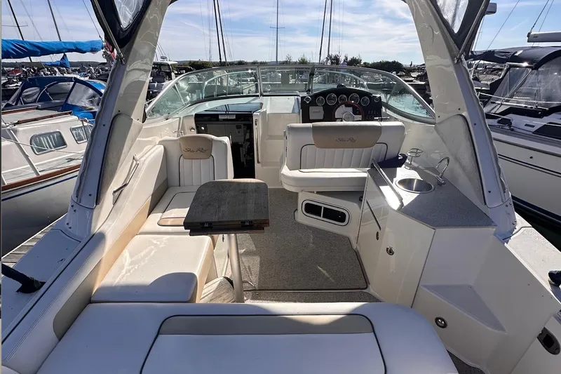 Slide: The Image of 2010 Sea Ray 310 Sundancer boat interior with seating, table, and helm at marina. - 4