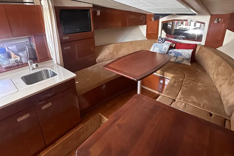 Slide: The Image of Interior of 2010 Sea Ray 310 Sundancer with cozy seating, table, and kitchenette. - 7