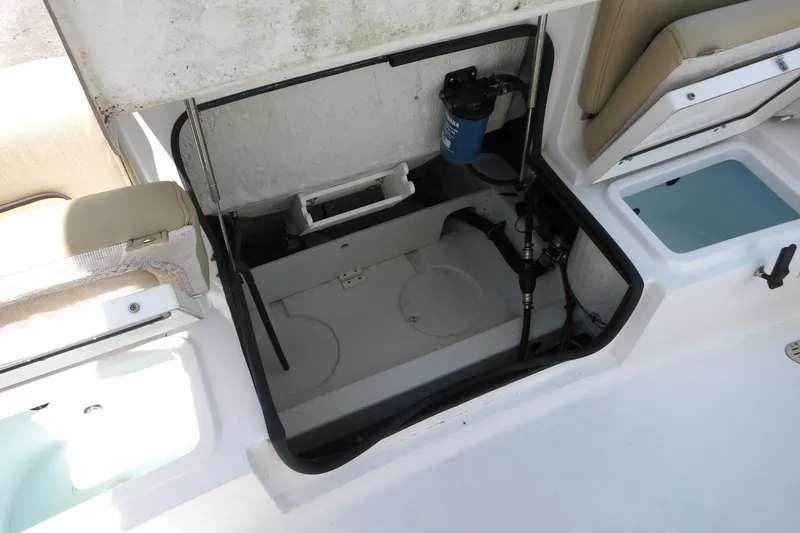 Slide: The Image of 2019 Sportsman Heritage 231 Center Console boat storage compartment open, revealing interior components. - 30