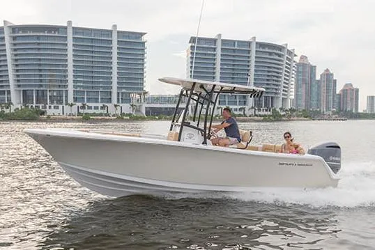Slide: The Image of Manufacturer Provided Image: 2019 Sportsman Heritage 231 Center Console boat cruising near modern waterfront buildings. - 33