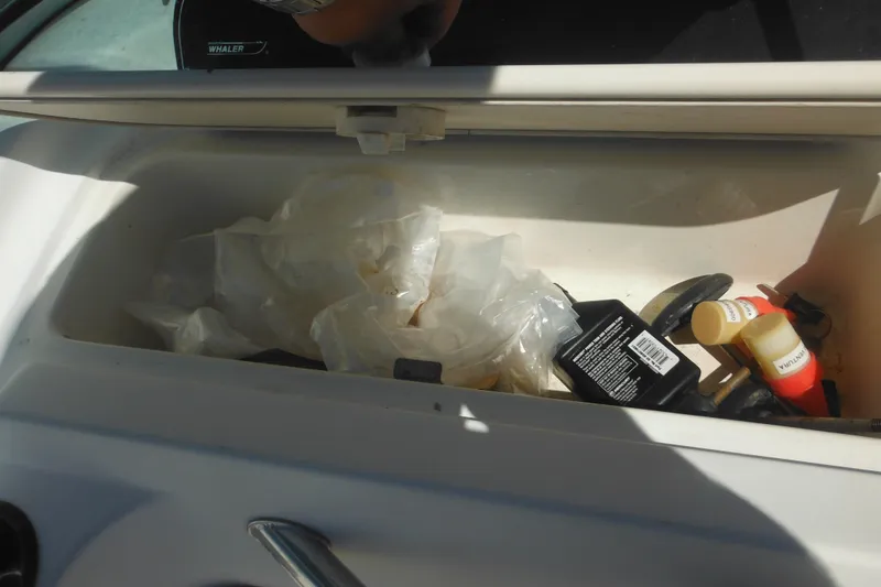 Slide: The Image of Storage compartment of a 2000 Boston Whaler 18 Ventura Bowrider with various items inside. - 22