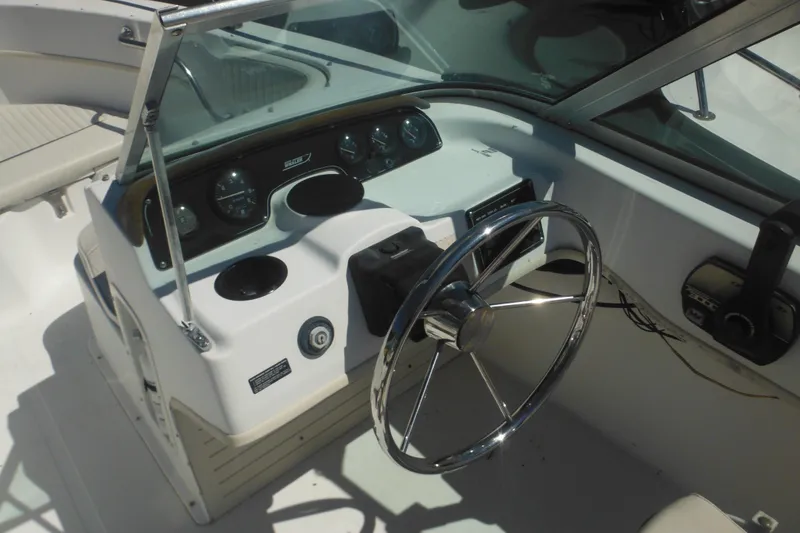 Slide: The Image of 2000 Boston Whaler 18 Ventura Bowrider dashboard with steering wheel and controls. - 23