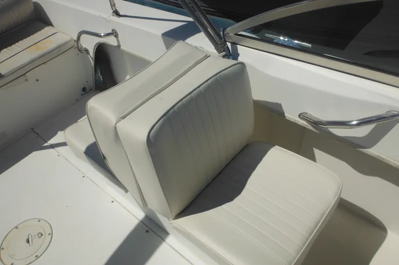 Slide: The Image of 2000 Boston Whaler 18 Ventura Bowrider interior with white seating and stainless steel handrails. - 28