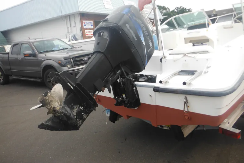 Slide: The Image of 2000 Boston Whaler 18 Ventura Bowrider with Mercury outboard motor in a parking lot. - 5