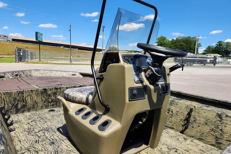 Slide: The Image of 2026 Tracker Grizzly 1860 CC boat interior with steering console and camouflage design. - 10