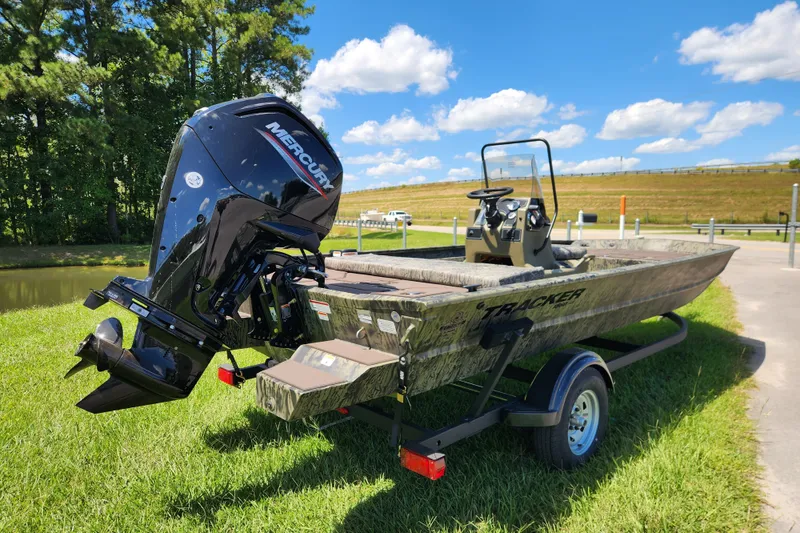 Slide: The Image of 2026 Tracker Grizzly 1860 CC boat with Mercury engine on trailer, outdoors. - 2