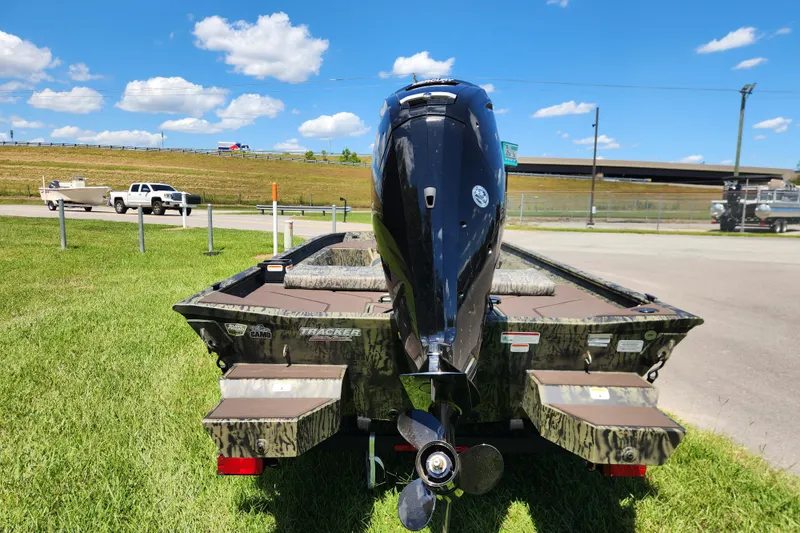 Slide: The Image of 2026 Tracker Grizzly 1860 CC boat with outboard motor on grassy area. - 3