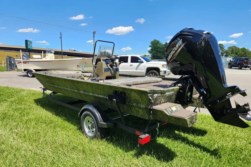 Slide: The Image of 2026 Tracker Grizzly 1860 CC boat with Mercury engine on trailer, parked on grass. - 4