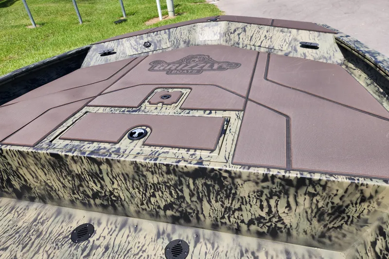 Slide: The Image of 2026 Tracker Grizzly 1860 CC boat with camouflage design and deck storage compartments. - 7