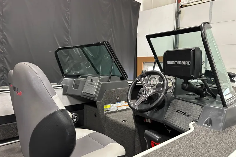 Slide: The Image of 2017 Alumacraft Trophy 185 boat interior with steering wheel and Humminbird electronics. - 12
