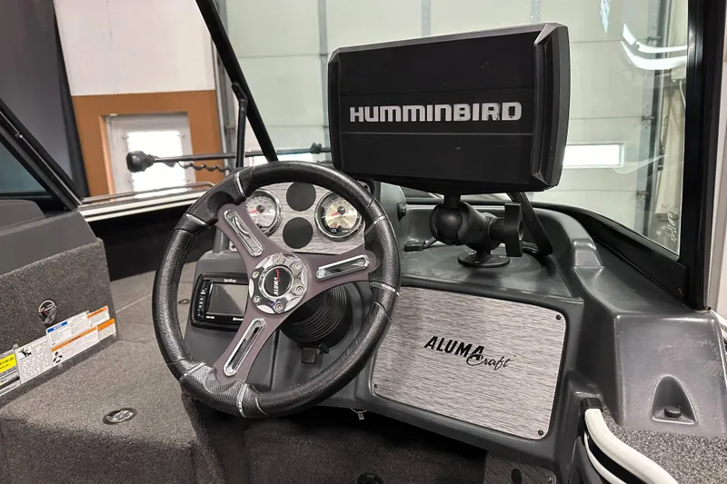 Slide: The Image of 2017 Alumacraft Trophy 185 dashboard with steering wheel and Humminbird fish finder. - 13