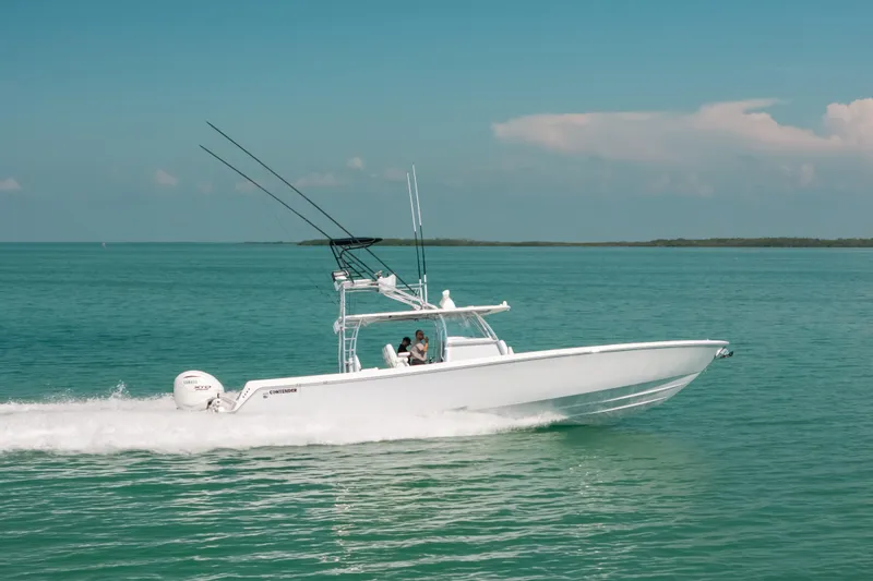 The Image of 2025 Contender 44 ST boat cruising on clear blue water. - 0