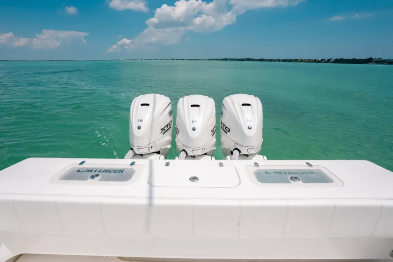 Slide: The Image of 2025 Contender 44 ST boat with triple outboard engines on turquoise water. - 13