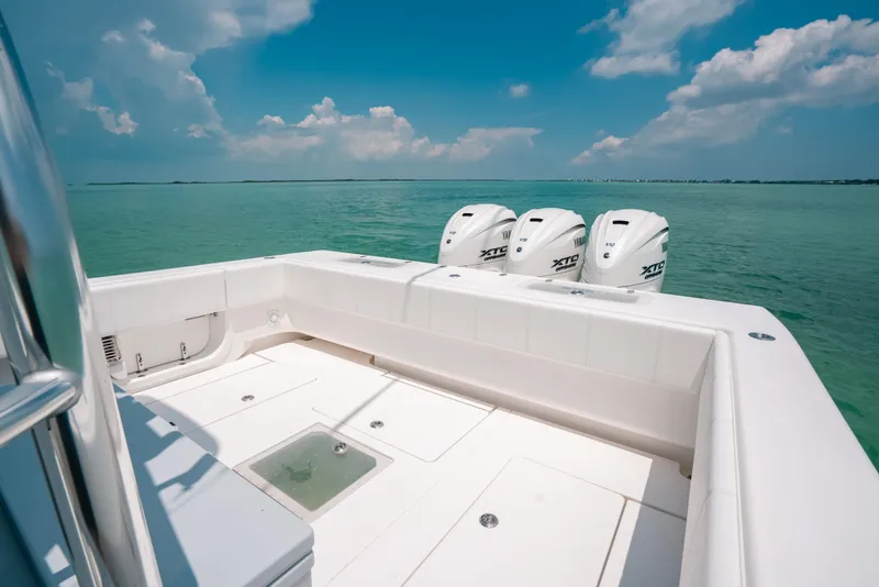 Slide: The Image of Contender 44 ST 2025 boat with triple outboard engines on clear blue water. - 14