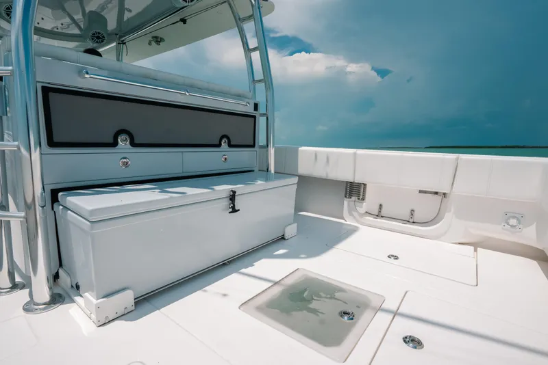 Slide: The Image of 2025 Contender 44 ST boat deck with storage compartments and seating under a clear sky. - 16