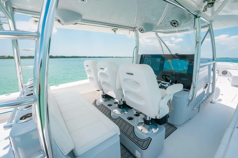 Slide: The Image of 2025 Contender 44 ST boat interior with modern helm and seating, cruising on clear waters. - 18