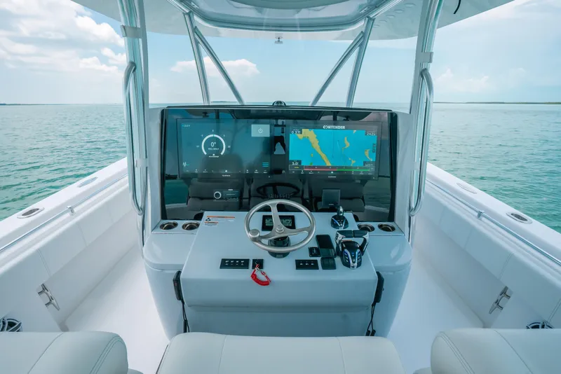 Slide: The Image of 2025 Contender 44 ST boat cockpit with advanced navigation system on open water. - 21
