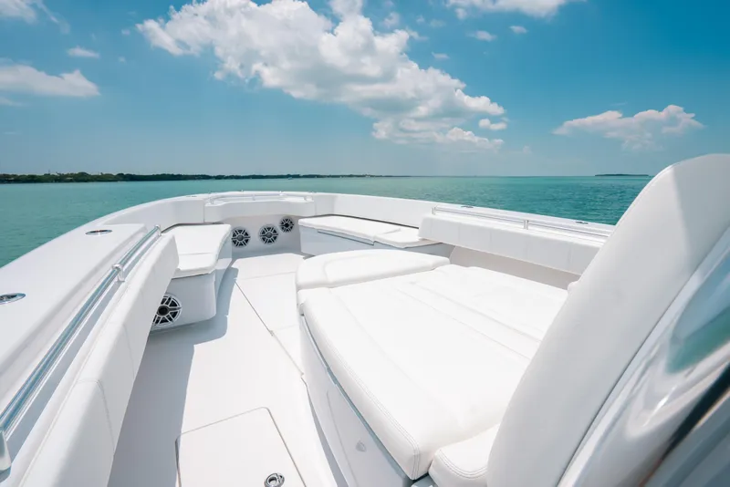 Slide: The Image of Luxurious 2025 Contender 44 ST boat interior with white seating, ocean view, and blue sky. - 24