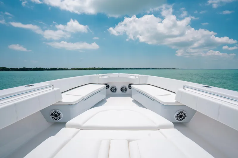 Slide: The Image of 2025 Contender 44 ST boat interior with white seating, set against a serene ocean backdrop. - 27