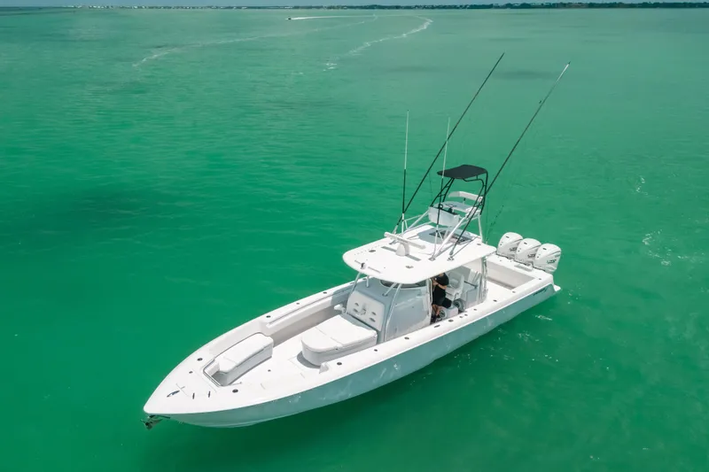 Slide: The Image of 2025 Contender 44 ST boat on turquoise water, equipped with multiple outboard engines. - 8