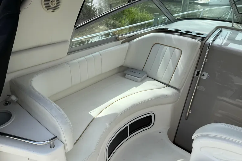 Slide: The Image of 1998 Sea Ray 290 Sundancer boat interior with white seating and Garmin device. - 10