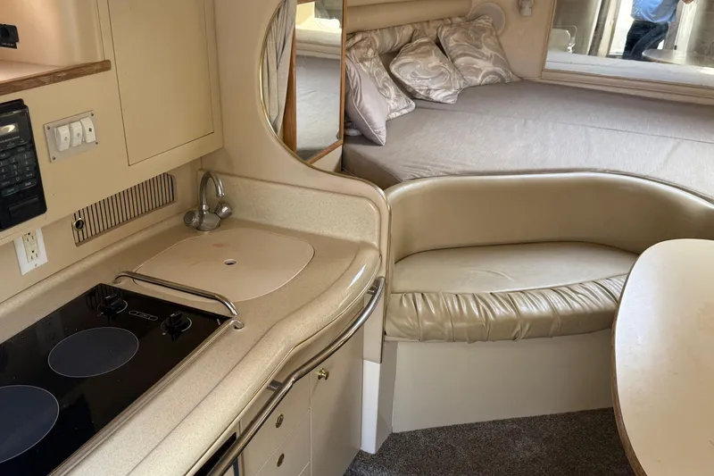 Slide: The Image of 1998 Sea Ray 290 Sundancer interior with kitchenette, seating, and bed. - 11