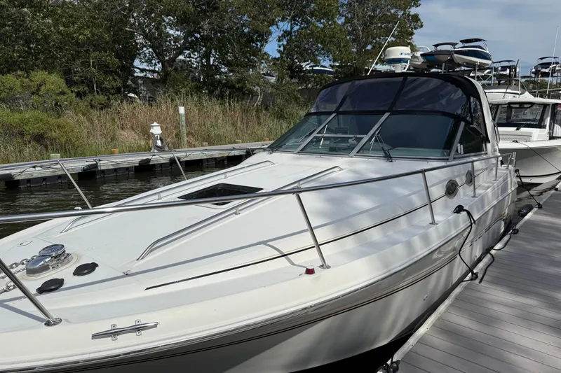 Slide: The Image of 1998 Sea Ray 290 Sundancer docked, featuring sleek design and spacious deck. - 5