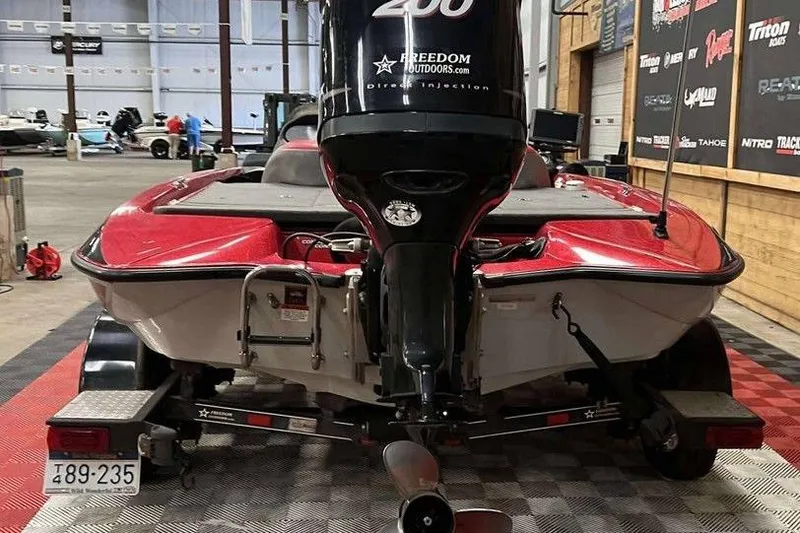 Slide: The Image of 2008 Stratos 294 XL boat with powerful outboard motor in showroom setting. - 4