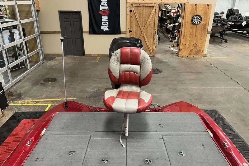 Slide: The Image of 2008 Stratos 294 XL boat with red and white seat in a garage setting. - 8