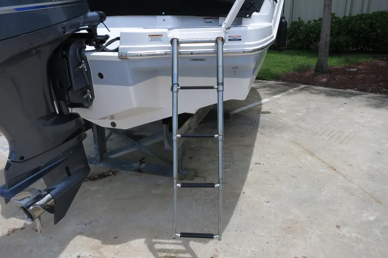 Slide: The Image of 2023 Chaparral 23 SSi OB boat with extended swim ladder and outboard motor. - 10