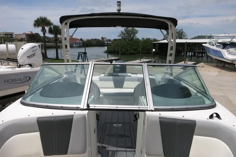 Slide: The Image of 2023 Chaparral 23 SSi OB boat docked, featuring sleek design and spacious seating. - 17