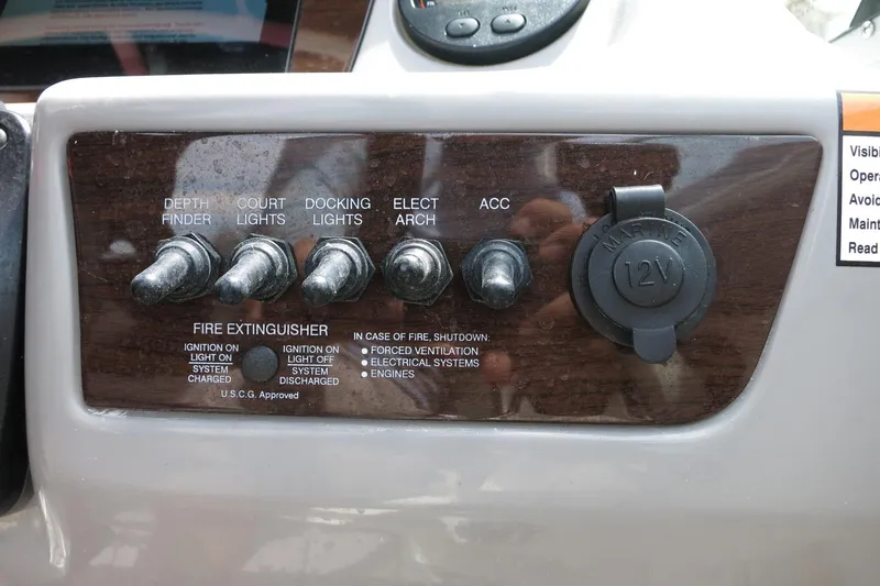 Slide: The Image of Control panel of 2023 Chaparral 23 SSi OB boat with switches and 12V outlet. - 24