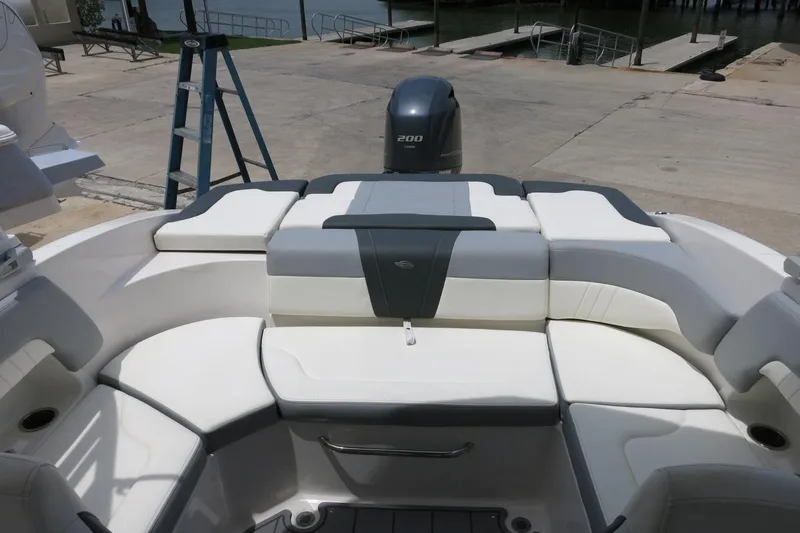 Slide: The Image of 2023 Chaparral 23 SSi OB boat with white and gray seating, dockside view. - 27