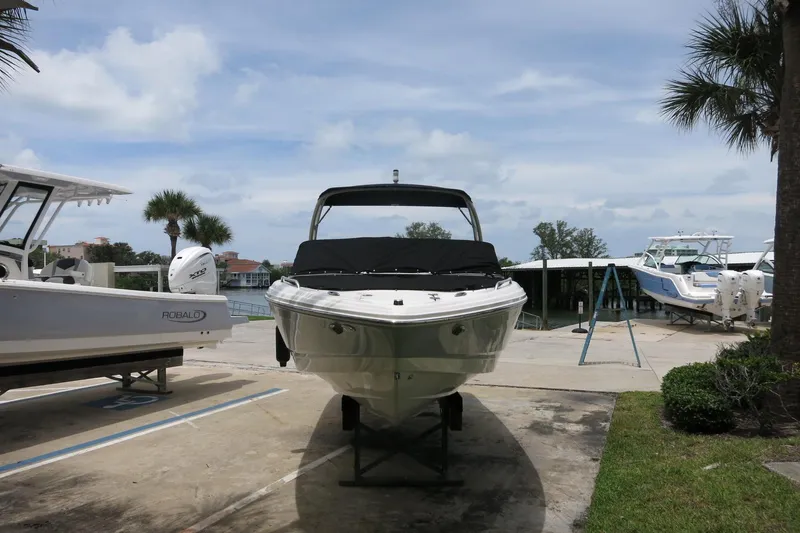 Slide: The Image of 2023 Chaparral 23 SSi OB boat on display at a marina with palm trees. - 3