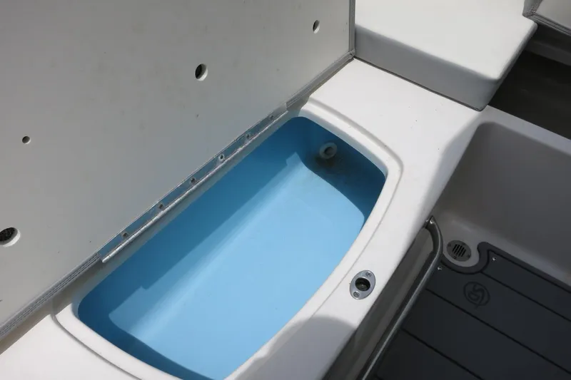 Slide: The Image of 2023 Chaparral 23 SSi OB boat storage compartment with open lid and blue interior. - 30