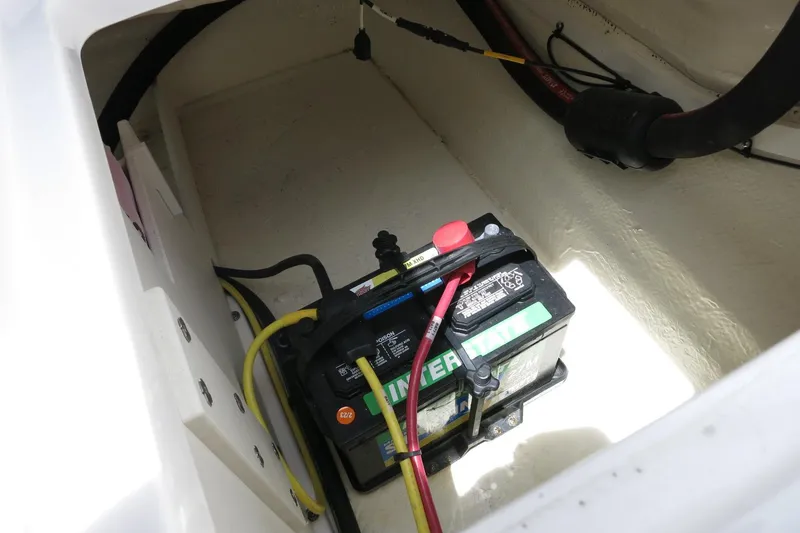 Slide: The Image of Battery compartment of 2023 Chaparral 23 SSi OB boat, featuring a PowerStart battery. - 33