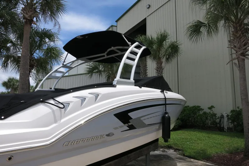 Slide: The Image of 2023 Chaparral 23 SSi OB boat with sleek design, docked near palm trees. - 5